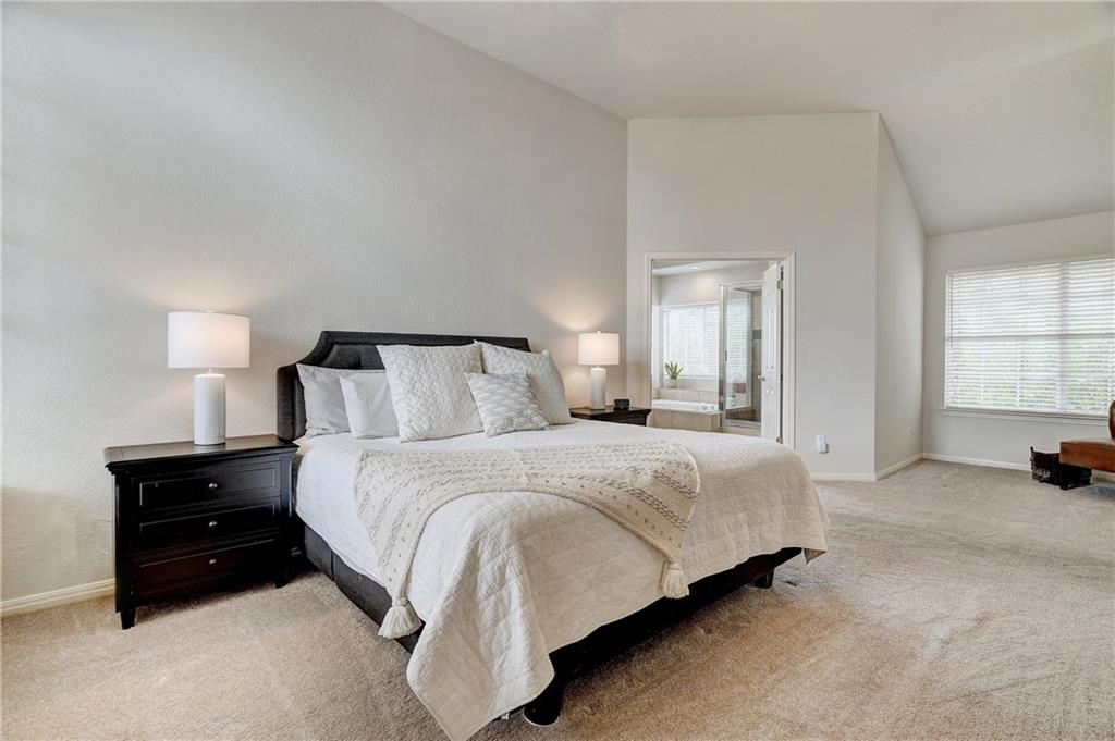 8504 Ephraim Road Austin, TX 78717 - Photo 11 of 16 Bedroom with light colored carpet, vaulted ceiling, and ensuite bathroom