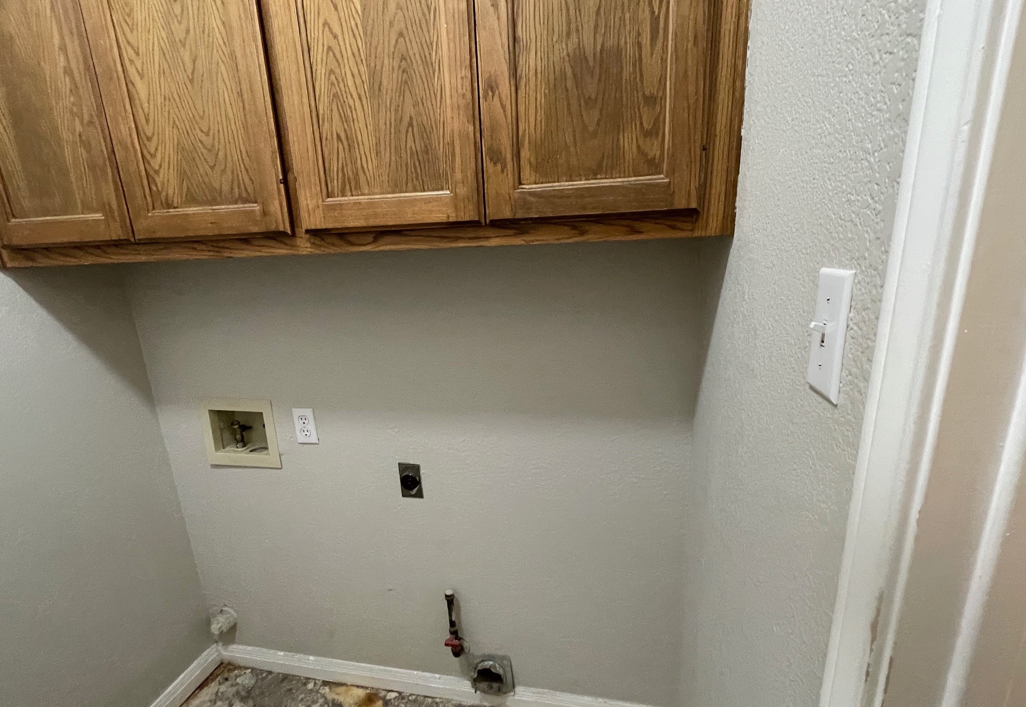 8504 Ephraim Road Austin, TX 78717 - Photo 12 of 16 Laundry room with cabinet space, hookup for a washing machine, a textured wall, and electric dryer hookup