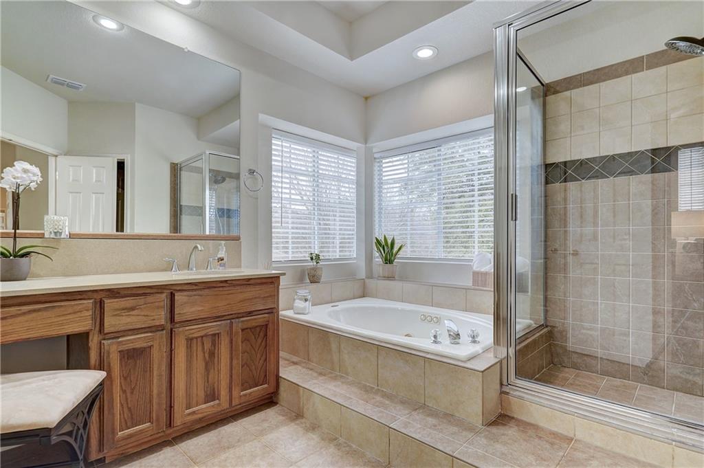 8504 Ephraim Road Austin, TX 78717 - Photo 14 of 16 Bathroom with vanity, a shower stall, a tub with jets, recessed lighting, and light tile patterned floors