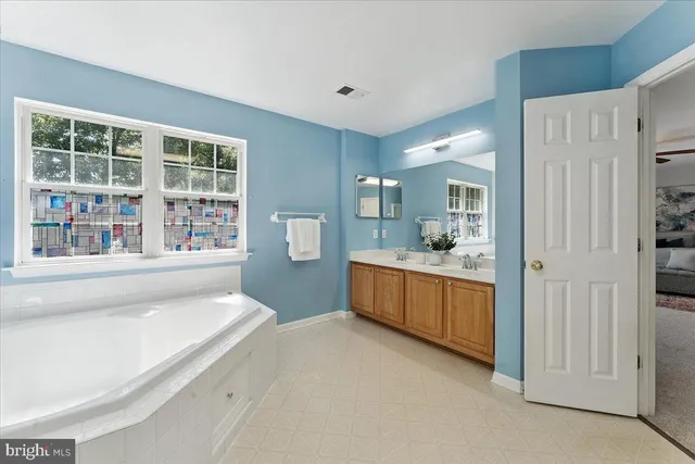 a spacious bathroom with a bathtub a window and a shower