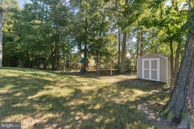 an empty room with ceiling fan and windows
