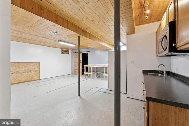 a picture of a wall with a white bed and a painting