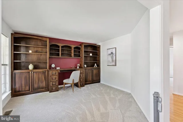 a view of an empty room with furniture and a window