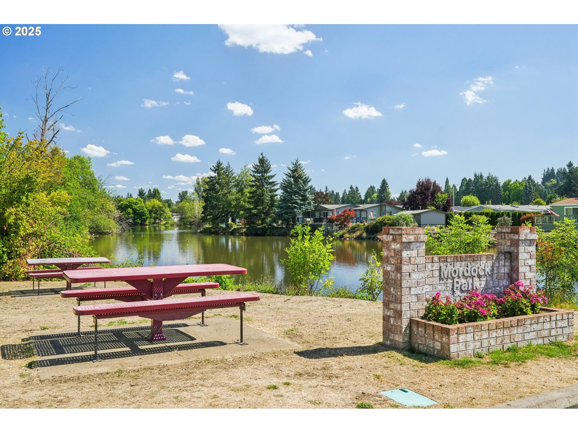 8434 Heritage Court, Unit 19 Clackamas, OR 97015 - Photo 28 of 28 a backyard view of a house with a lake and a bench