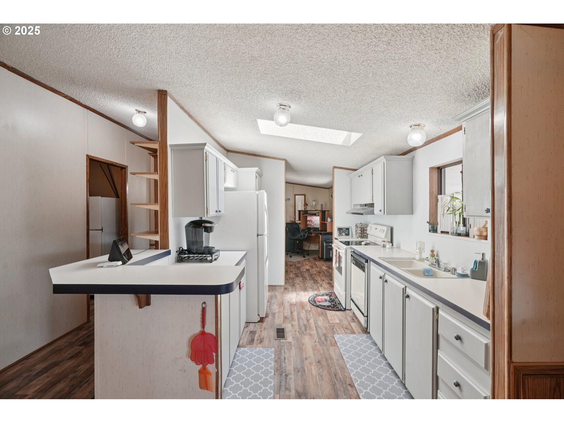 8434 Heritage Court, Unit 19 Clackamas, OR 97015 - Photo 8 of 28 a kitchen with kitchen island a sink appliances and cabinets