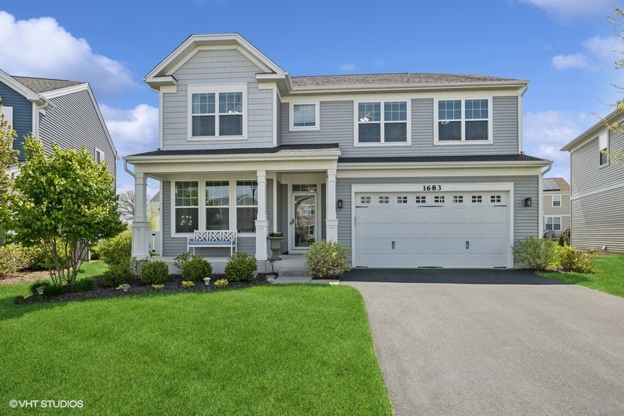 1683 Rockefeller Drive Mundelein, IL 60060 - Photo 1 of 25 a front view of a house with a yard and garage