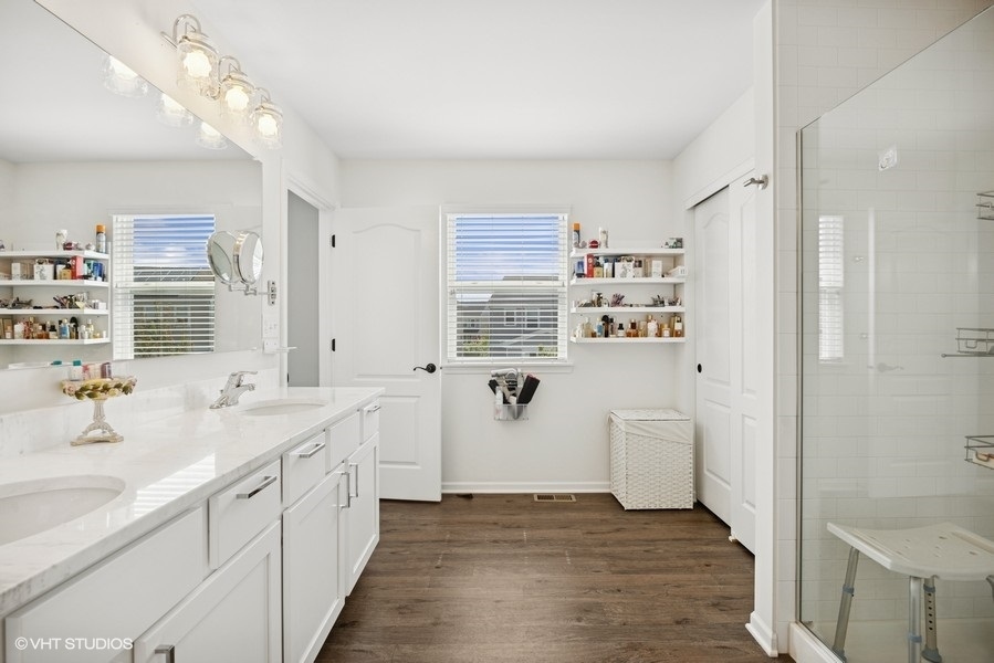 1683 Rockefeller Drive Mundelein, IL 60060 - Photo 14 of 25 a bathroom with a double vanity sink a mirror and a bathtub
