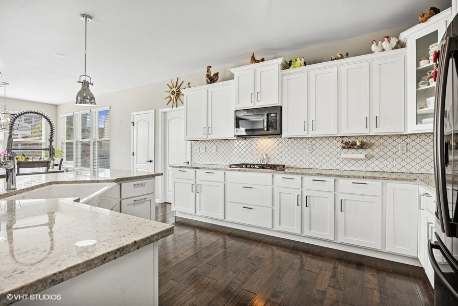 1683 Rockefeller Drive Mundelein, IL 60060 - Photo 9 of 25 a kitchen with stainless steel appliances granite countertop a sink a stove and a refrigerator