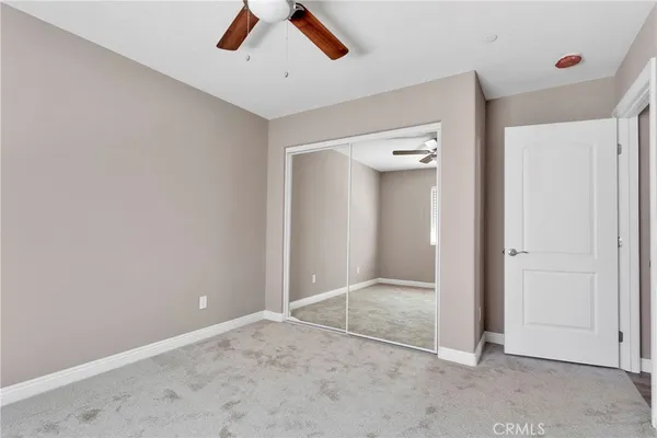 an empty room with fan and entryway
