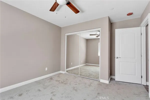 an empty room with fan and entryway