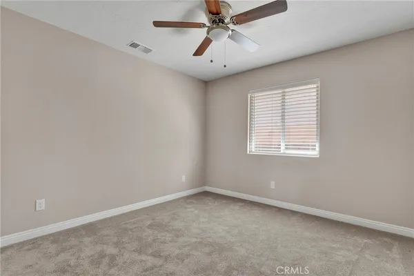 an empty room with a window and a fan