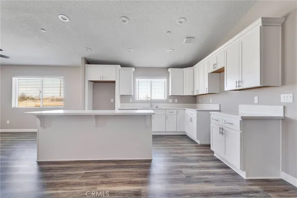 a kitchen with white cabinets and appliances