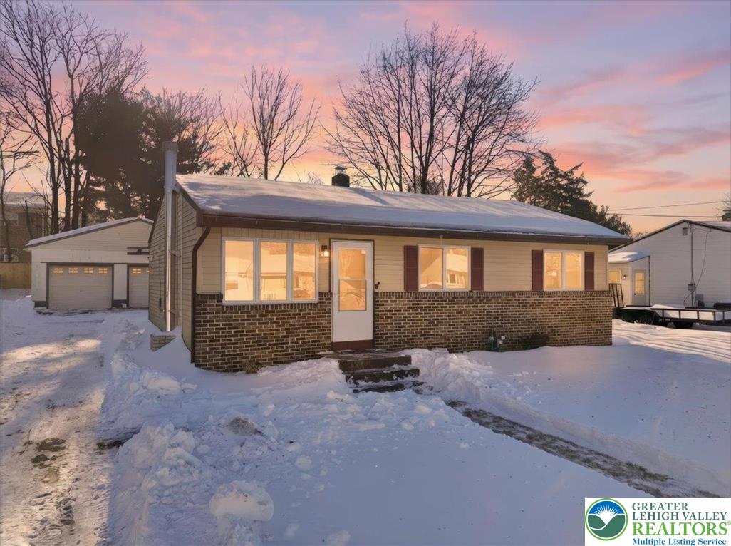 a view of a house with a yard covered in snow