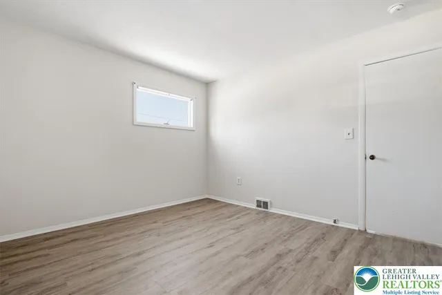 a view of a room with wooden floor and white walls