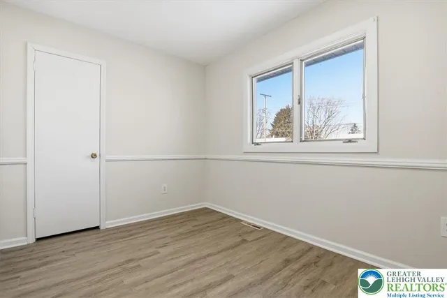 a view of a small space with wooden floor and a window