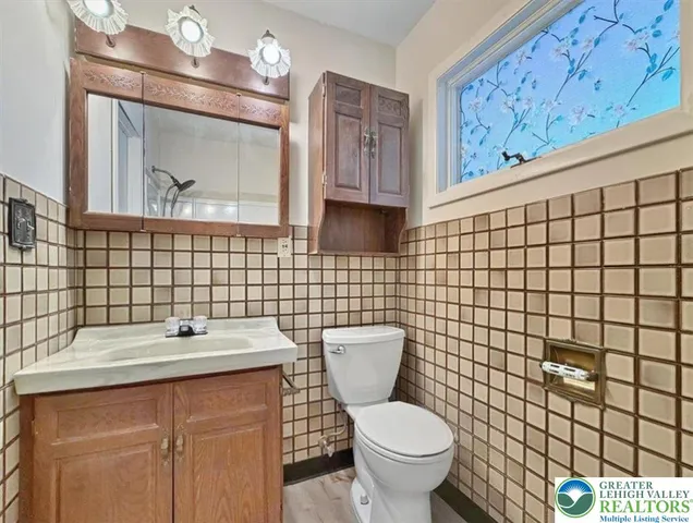 a bathroom with a toilet sink vanity and mirror