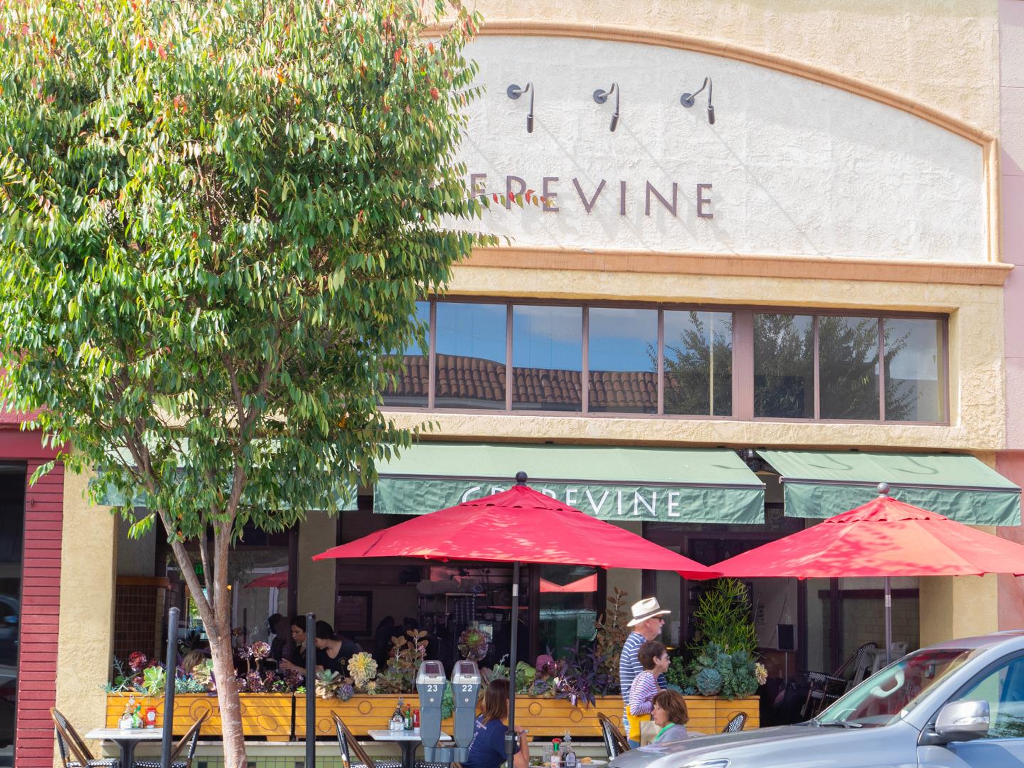 525 Almer Road, Unit 210 Burlingame, CA 94010 - Photo 31 of 36 a view of a cafe with a table and chairs under an umbrella