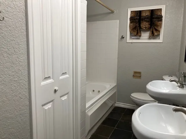 a bathroom with a toilet a sink and bathtub