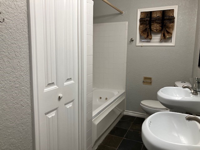 111 Shadylyn Drive Conroe, TX 77304 - Photo 14 of 18 a bathroom with a toilet a sink and bathtub