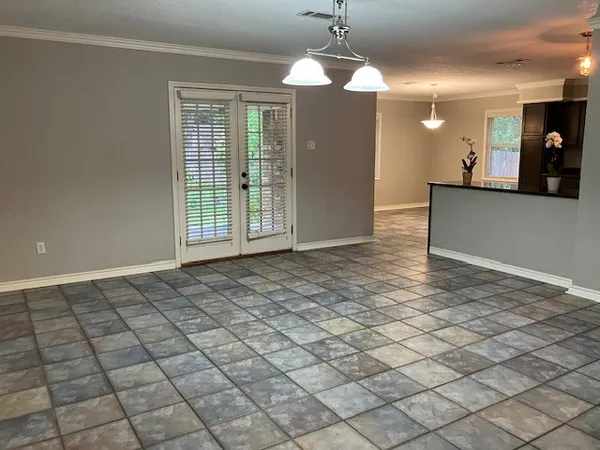 a view of a livingroom with a chandelier fan and windows