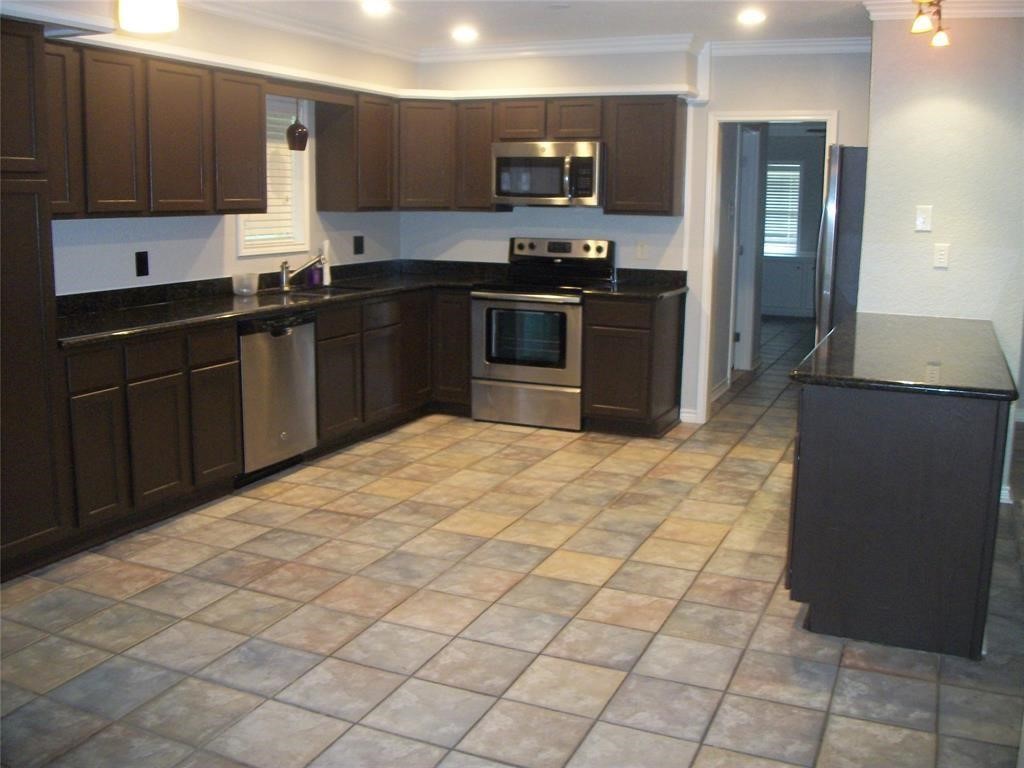 111 Shadylyn Drive Conroe, TX 77304 - Photo 7 of 18 a kitchen with stainless steel appliances a sink and cabinets