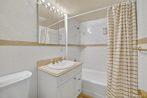 a bathroom with a granite countertop sink a toilet and shower