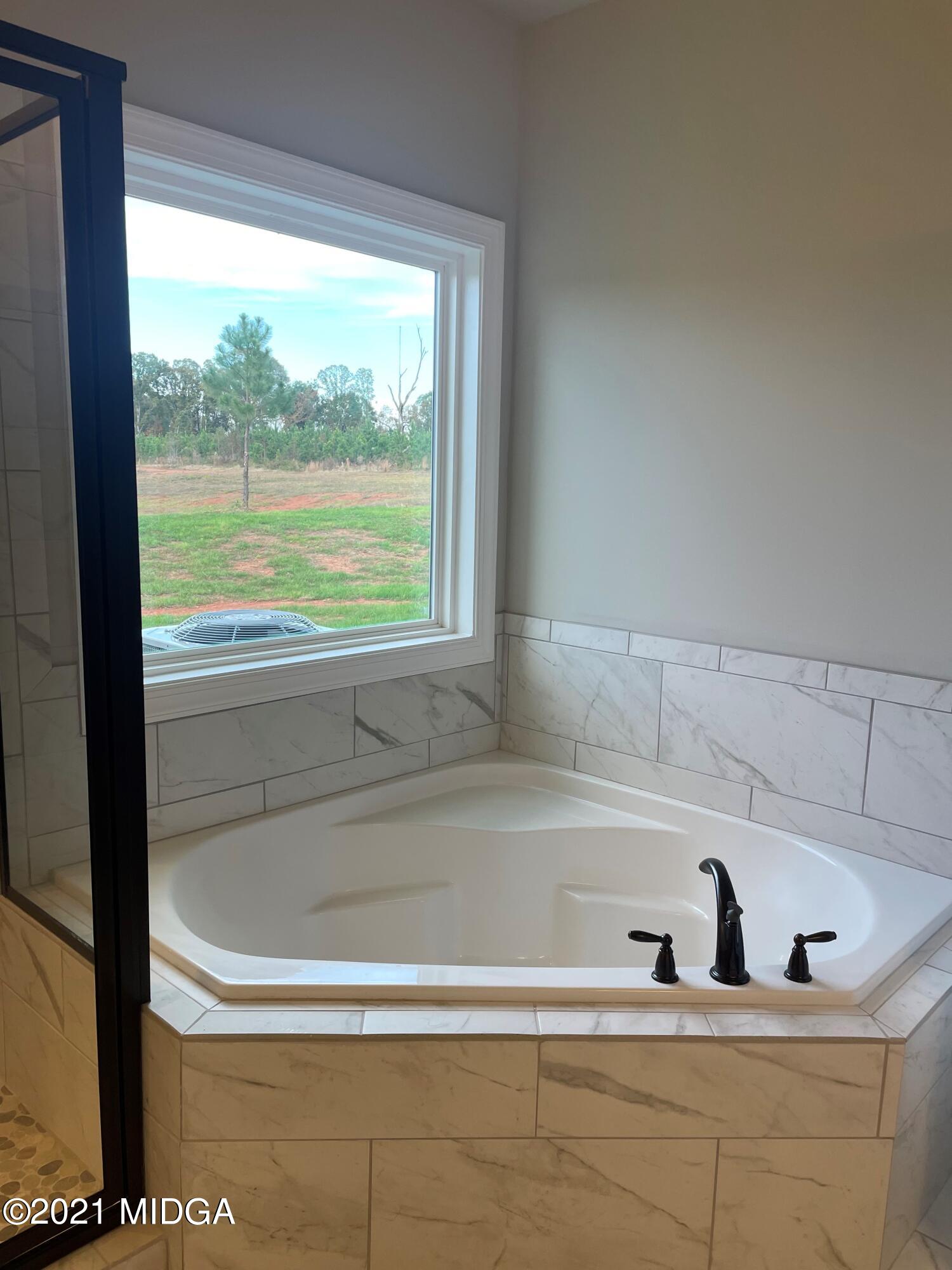 1154 Bunn Road Forsyth, GA 31029 - Photo 7 of 9 a bath tub sitting next to a window