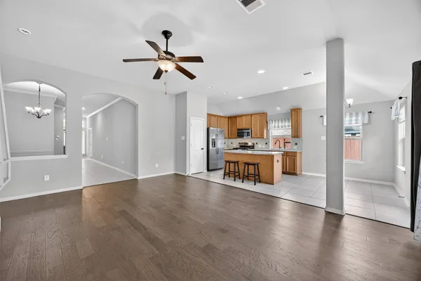 a view of a kitchen with refrigerator and wooden floor
