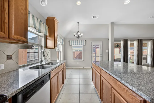 a large kitchen with granite countertop a sink and cabinets