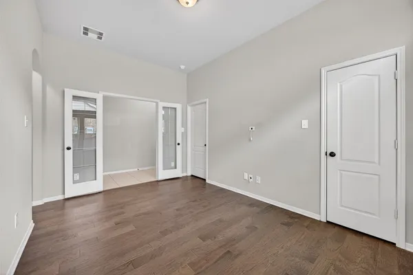 an empty room with wooden floor & closet area