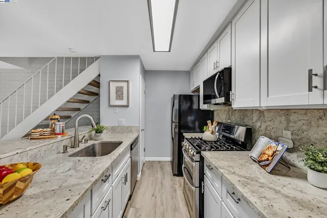 a kitchen with stainless steel appliances granite countertop a sink stove and refrigerator