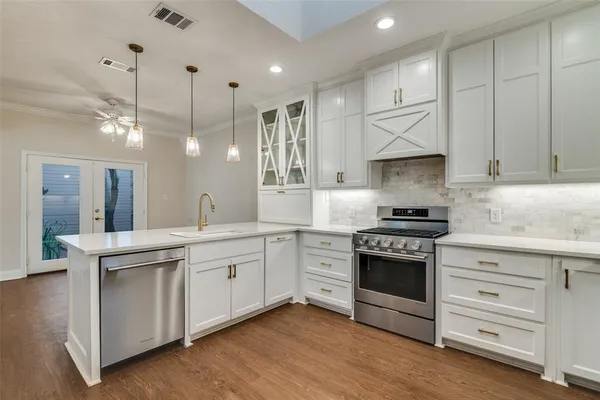 a kitchen with stainless steel appliances granite countertop a sink a stove and a refrigerator