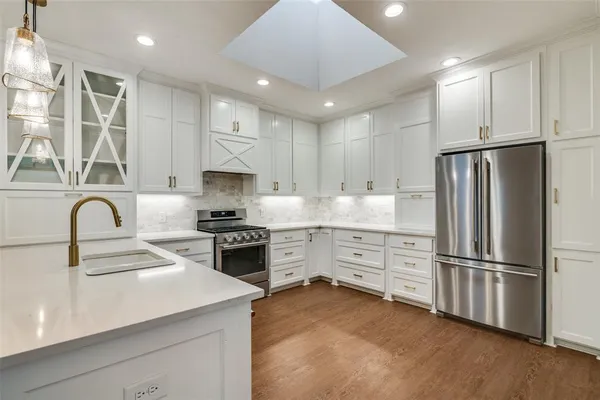 a kitchen with kitchen island a sink a stove and wooden floor