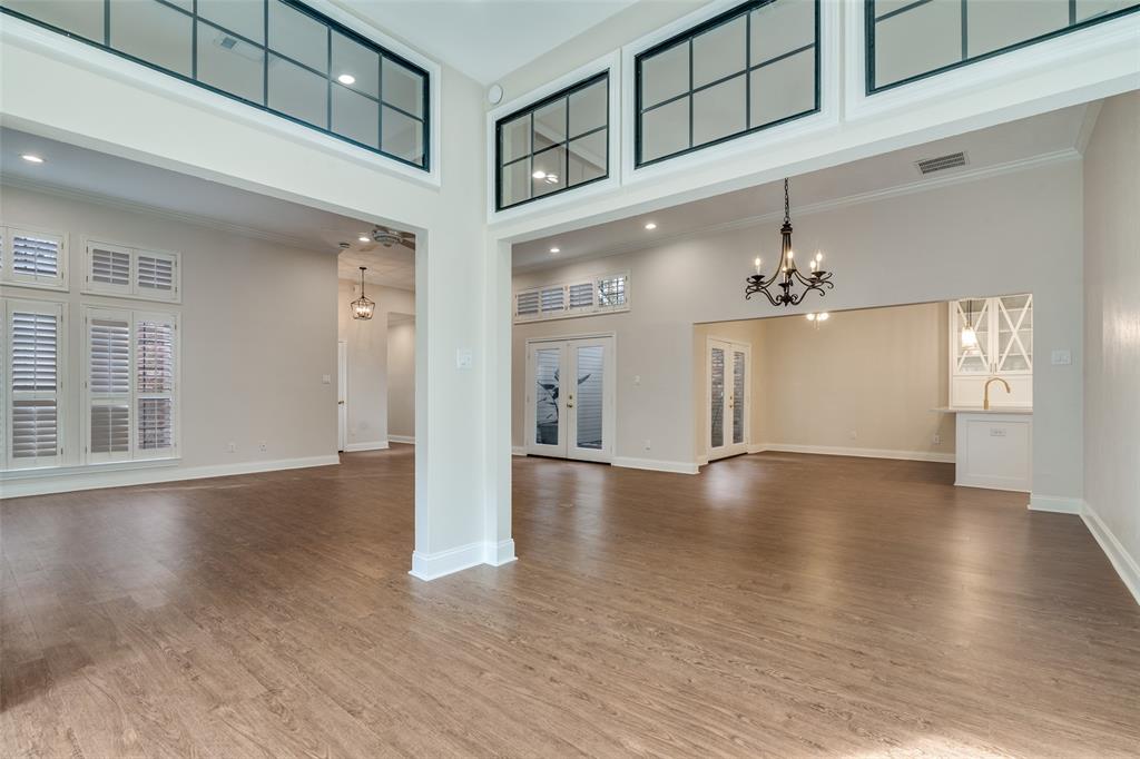 6027 High Court Place Dallas, TX 75254 - Photo 8 of 26 an empty room with wooden floor chandelier and windows