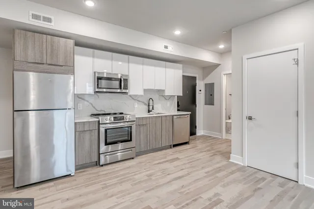 a kitchen with stainless steel appliances a refrigerator sink and microwave