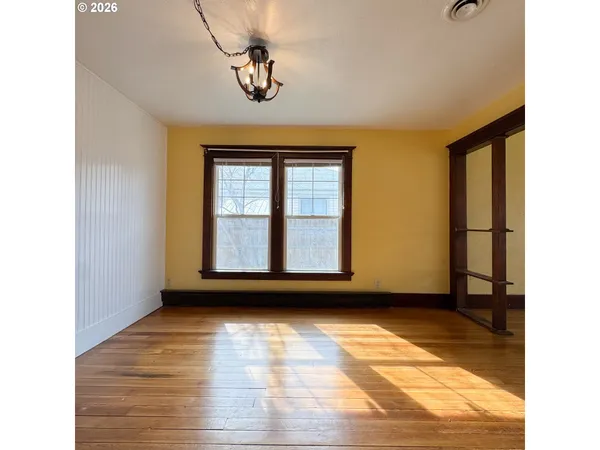 a view of empty room with wooden floor