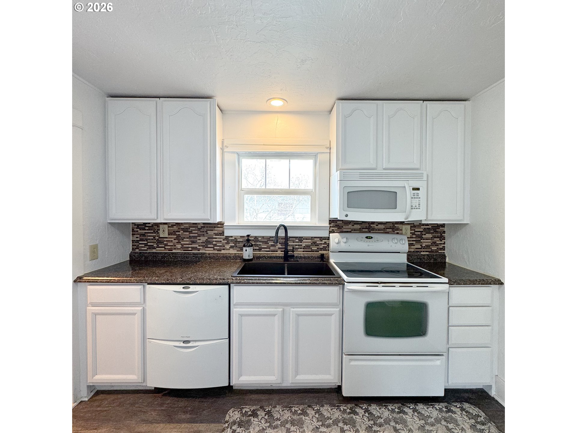 2414 3rd Street Baker City, OR 97814 - Photo 6 of 23 a kitchen with white cabinets and white appliances