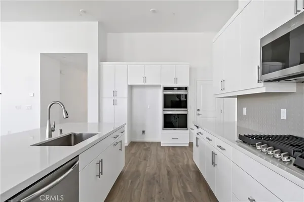 a kitchen with stainless steel appliances a sink stove and refrigerator