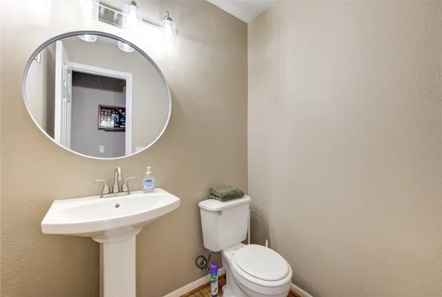 a bathroom with a toilet a sink and mirror