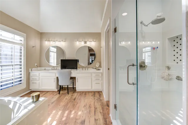 a bathroom with a double vanity sink mirror and shower