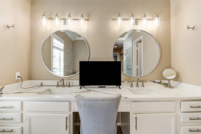 a bathroom with double vanity and a mirror
