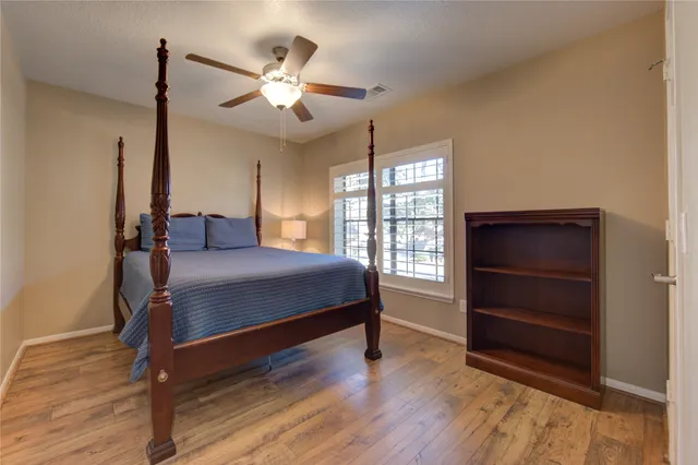 a bedroom with a bed and a ceiling fan