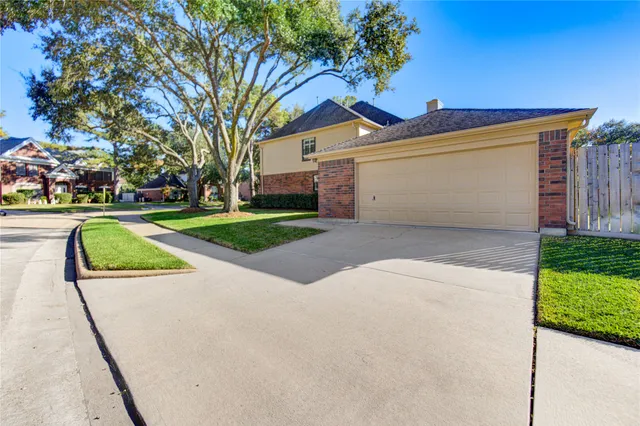 a view of a house with a yard and large tree