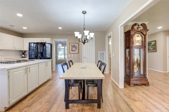 a kitchen with stainless steel appliances kitchen island granite countertop a kitchen island hardwood floor sink stove dining table and chairs