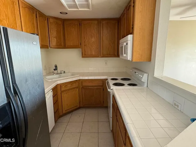 a kitchen with a refrigerator sink and cabinets