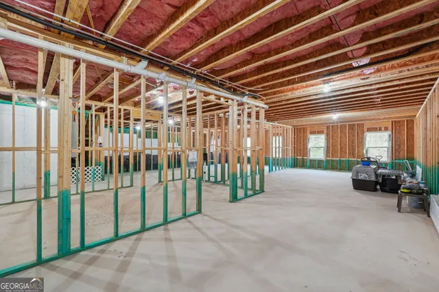 a view of a white house in front of a big yard with large trees