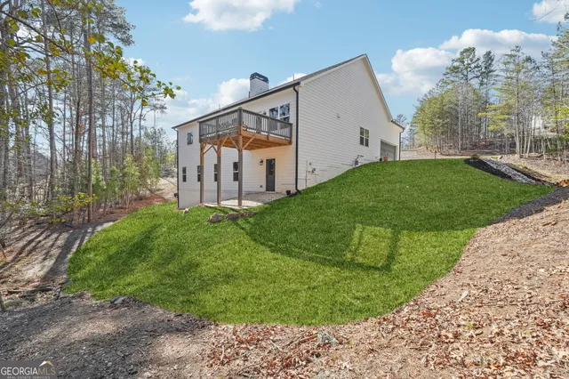 a aerial view of a house with a yard and large trees