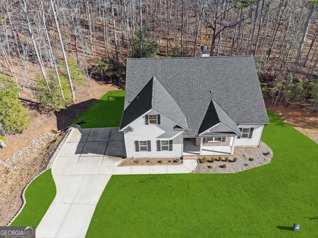 an aerial view of a house with a yard and mountain view
