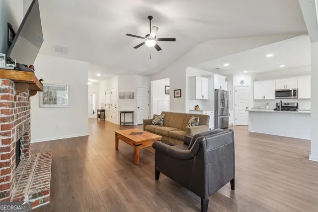 a living room with furniture a fireplace and a flat screen tv