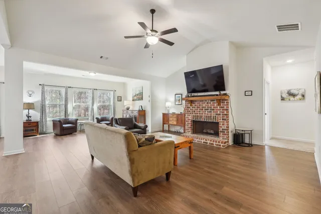 a living room with furniture a fireplace and a flat screen tv